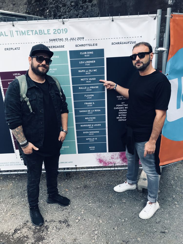 Mark Netty and Hugo in front of a 2019 festival timetable listing Netty Hugo